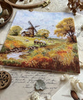 „Prie seno malūno“ – kryželiu siuvinėjimo komplektas, 19×19 cm - kaSiulai.lt