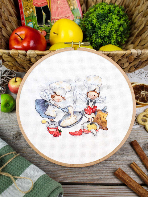Siuvinėjimo rinkinys kryželiu „Pirmas blynas“ – virtuvės fėjų motyvas, 10x12 cm, balta 14 ct drobė